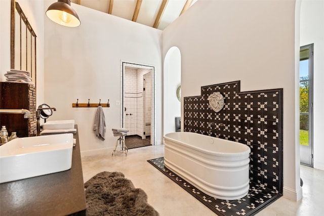 bathroom featuring concrete floors, high vaulted ceiling, sink, a bath to relax in, and beam ceiling