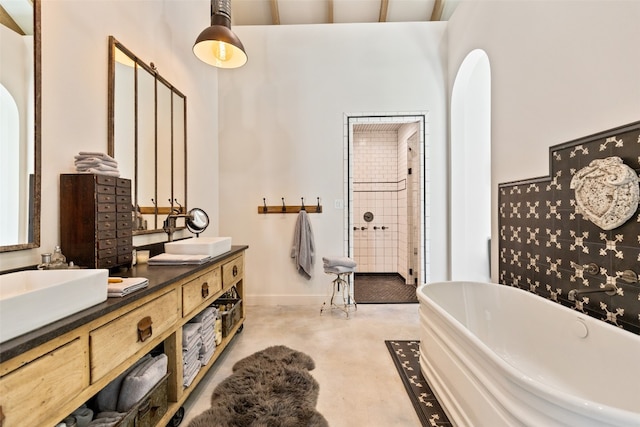 bathroom with a bath and dual bowl vanity