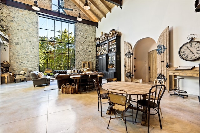 dining space featuring high vaulted ceiling, beamed ceiling, and ceiling fan