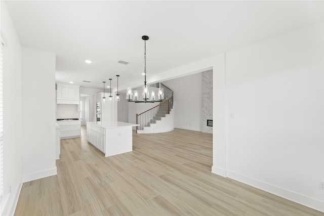 unfurnished dining area with a chandelier and light wood-type flooring