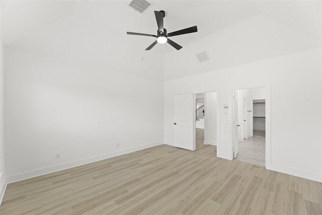 unfurnished bedroom with ceiling fan, light hardwood / wood-style flooring, and a spacious closet