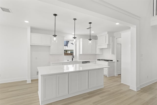 kitchen with white cabinetry, light hardwood / wood-style flooring, and a kitchen island