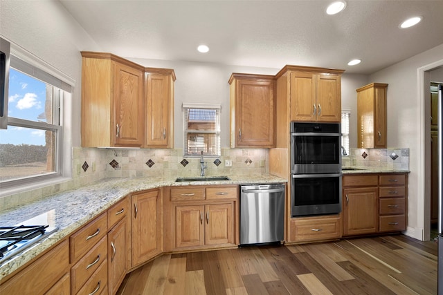 kitchen featuring stainless steel appliances, tasteful backsplash, dark wood-type flooring, and sink