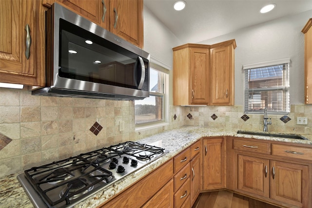 kitchen featuring backsplash, stainless steel appliances, plenty of natural light, and sink