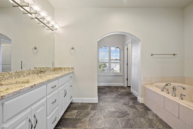 bathroom featuring vanity and a relaxing tiled tub