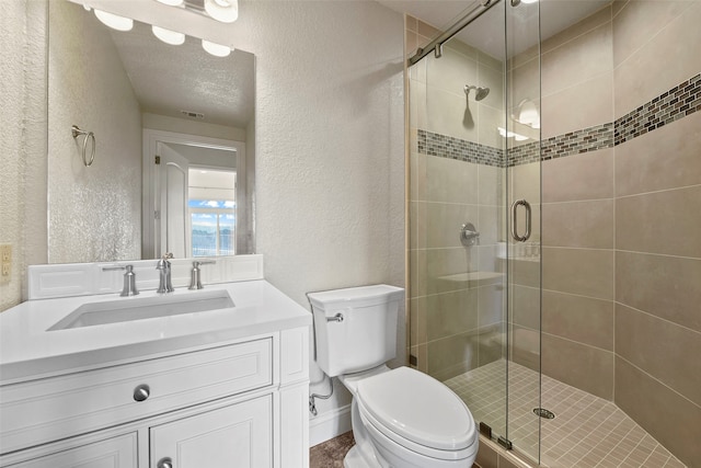 bathroom featuring vanity, toilet, and a shower with shower door