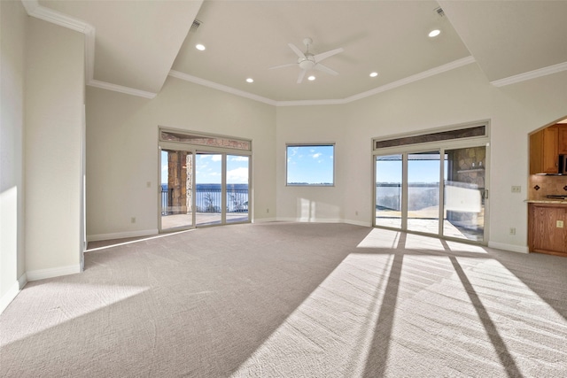 unfurnished living room with ceiling fan, crown molding, a towering ceiling, and light carpet