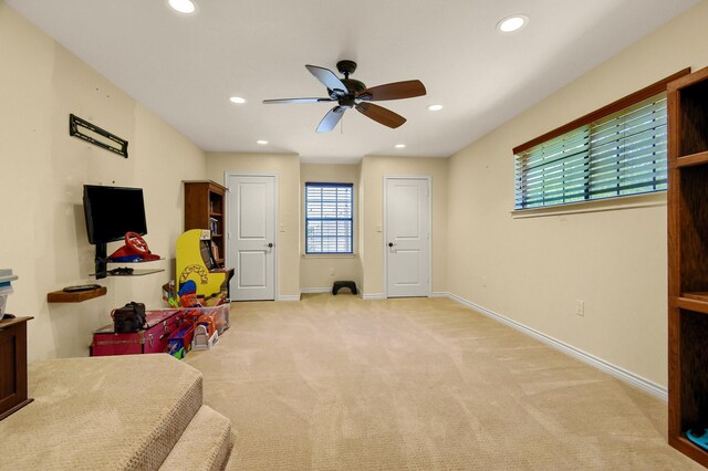 game room featuring light carpet and ceiling fan