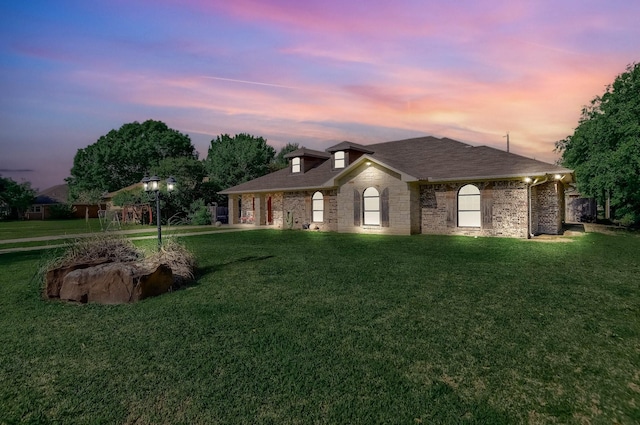 property exterior at dusk with a yard