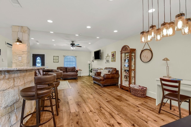 living room with ceiling fan, light hardwood / wood-style floors, and indoor bar