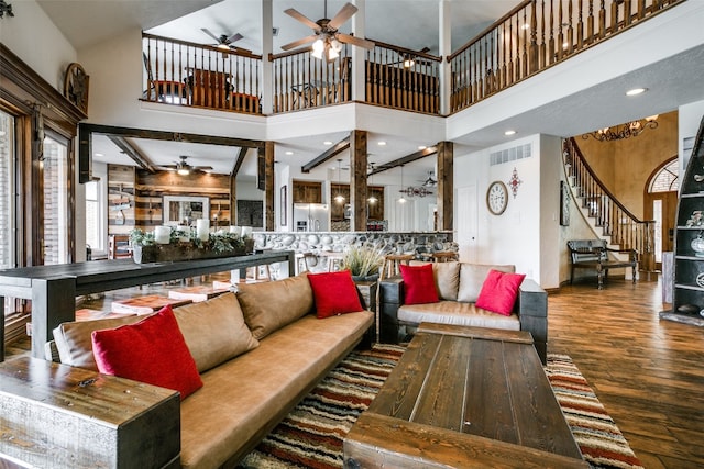 living room featuring ceiling fan, dark hardwood / wood-style floors, and a towering ceiling