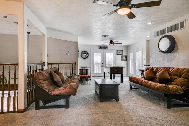 living room featuring french doors, a textured ceiling, dark carpet, and ceiling fan