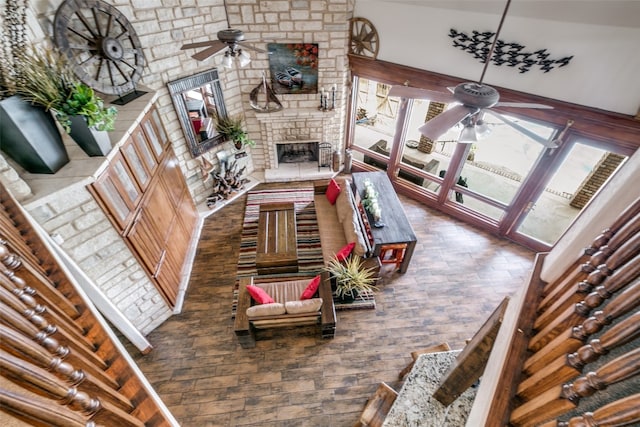 living room featuring a large fireplace, high vaulted ceiling, and ceiling fan