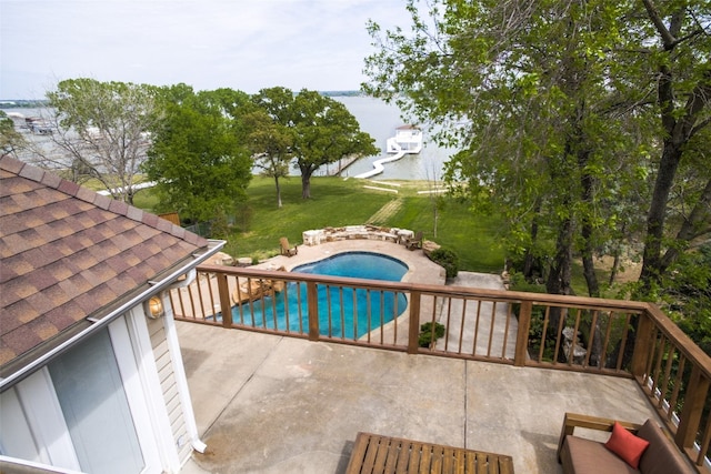 view of pool with a water view, a lawn, and a patio area