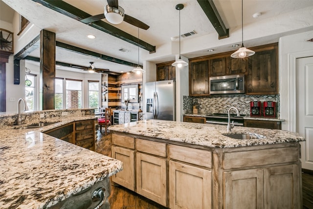 kitchen with appliances with stainless steel finishes, ceiling fan, beamed ceiling, and decorative light fixtures