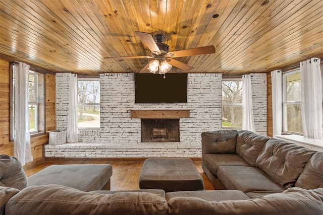 living room with a brick fireplace, wood ceiling, ceiling fan, and hardwood / wood-style flooring