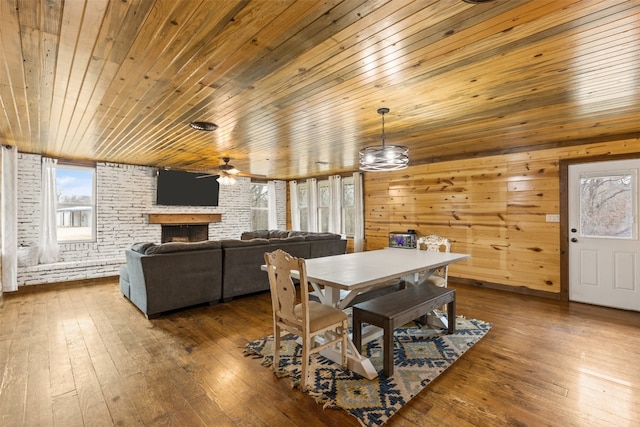 dining area with wood walls, dark hardwood / wood-style flooring, brick wall, and wooden ceiling