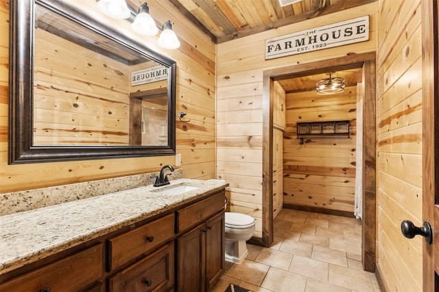 bathroom featuring tile floors, large vanity, wood walls, toilet, and wood ceiling