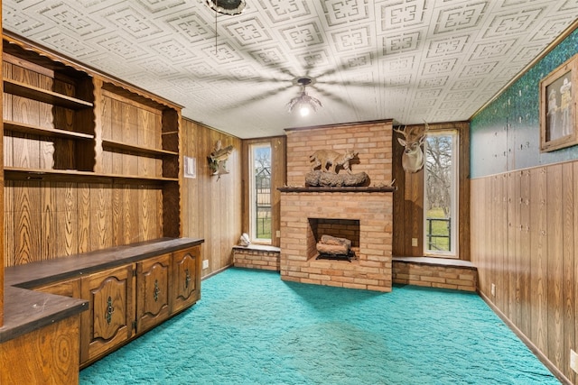 office space featuring brick wall, a brick fireplace, wood walls, and carpet