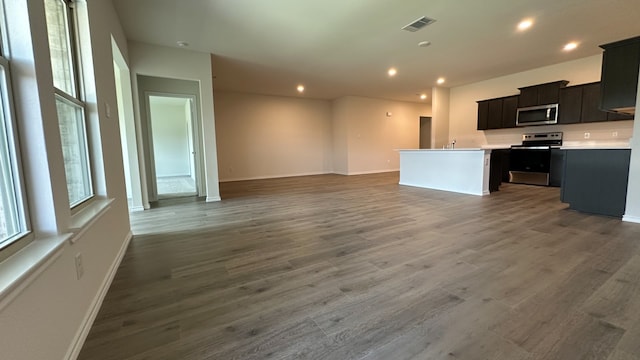 kitchen with dark wood-type flooring, a center island, and appliances with stainless steel finishes