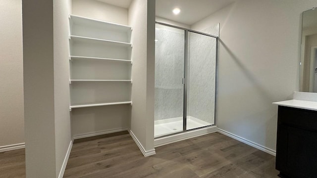 bathroom featuring hardwood / wood-style flooring, vanity, and walk in shower