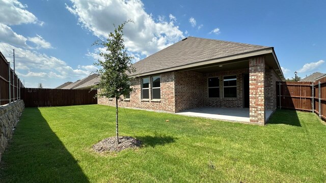 rear view of property with a patio area and a lawn