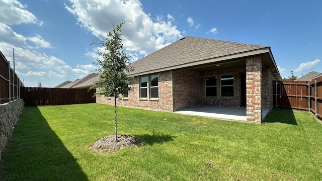 rear view of property with a yard and a patio