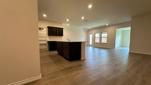 kitchen featuring an island with sink, dark wood-type flooring, and sink