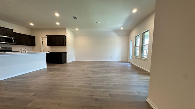 unfurnished living room featuring sink and light hardwood / wood-style floors