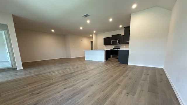 unfurnished living room with sink and wood-type flooring