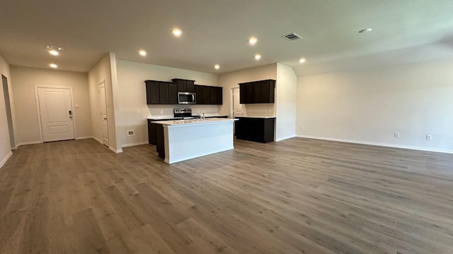 kitchen featuring a kitchen island with sink, sink, dark wood-type flooring, and stainless steel appliances