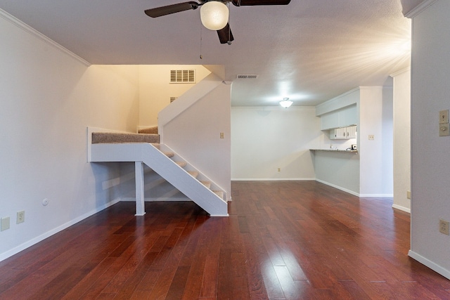 unfurnished living room featuring dark hardwood / wood-style floors, ceiling fan, and ornamental molding