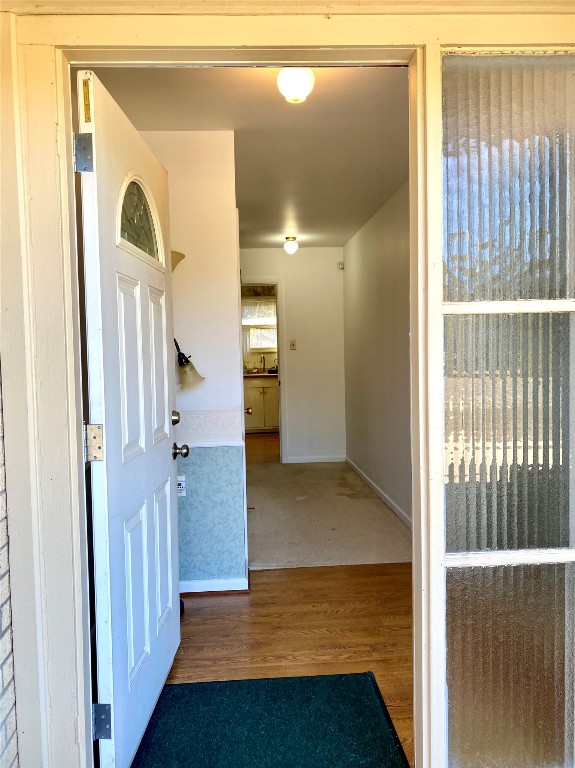 hallway featuring a wealth of natural light and dark colored carpet