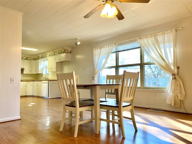 dining area featuring sink, light hardwood / wood-style floors, and ceiling fan