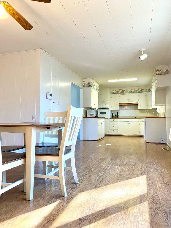 kitchen featuring ceiling fan, oven, and hardwood / wood-style flooring