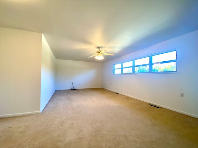 spare room featuring light carpet and ceiling fan