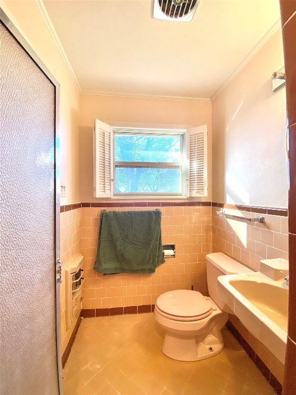 bathroom with tile walls, toilet, sink, tile floors, and ornamental molding