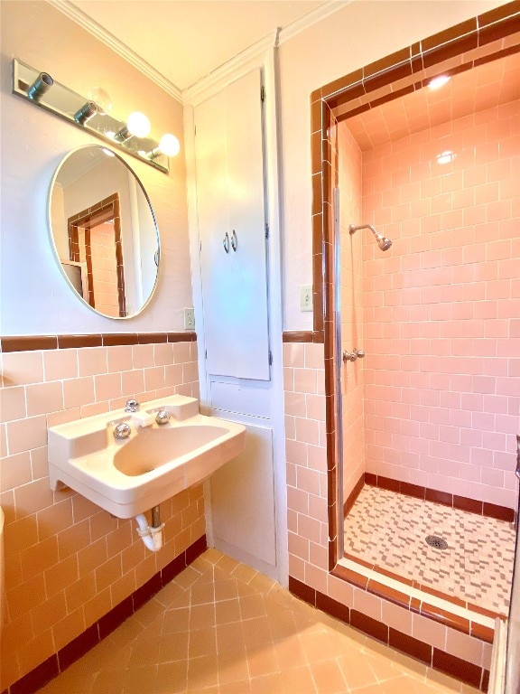 bathroom featuring walk in shower, tile floors, tile walls, ornamental molding, and sink