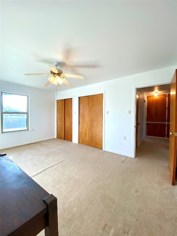 interior space featuring light colored carpet and ceiling fan