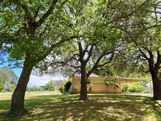 view of home's exterior with a lawn and a carport