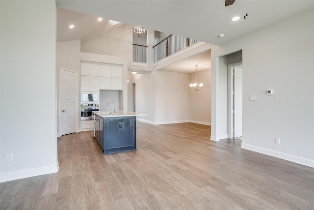 kitchen with white cabinets, sink, a center island with sink, light hardwood / wood-style flooring, and stainless steel appliances