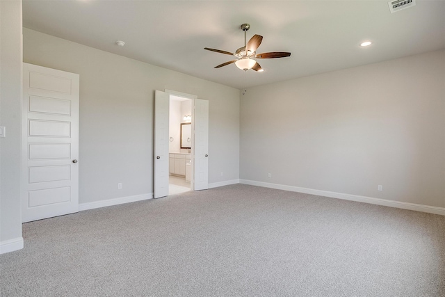 unfurnished bedroom featuring ensuite bath, ceiling fan, and light colored carpet