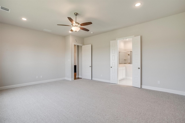 unfurnished bedroom featuring ceiling fan, light colored carpet, and ensuite bathroom