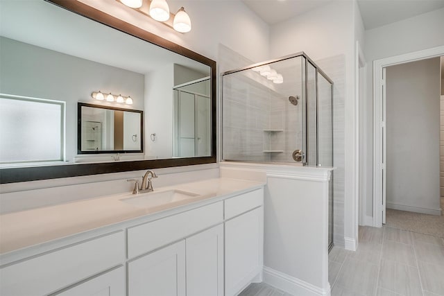 bathroom with a shower with shower door and vanity