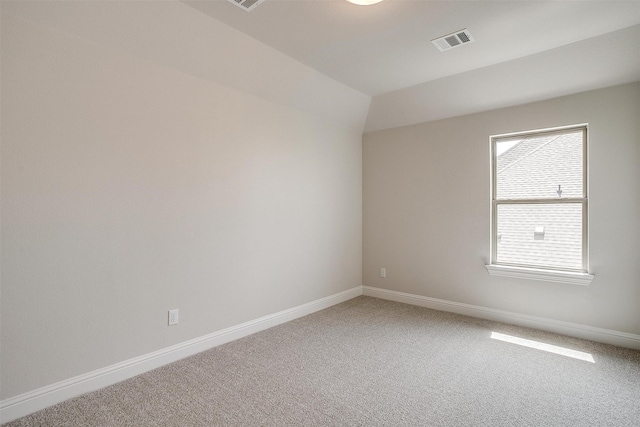 carpeted spare room featuring lofted ceiling