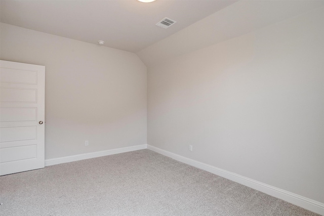 empty room with vaulted ceiling and carpet floors