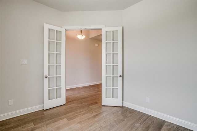 empty room with hardwood / wood-style floors and french doors