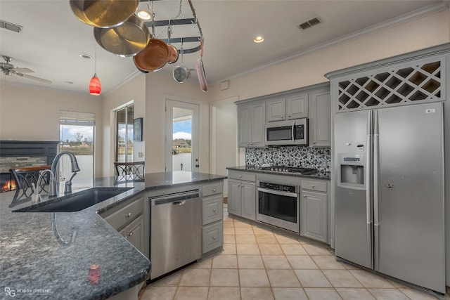 kitchen featuring gray cabinetry, tasteful backsplash, ceiling fan, and appliances with stainless steel finishes