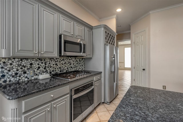 kitchen with light tile flooring, appliances with stainless steel finishes, crown molding, gray cabinetry, and backsplash