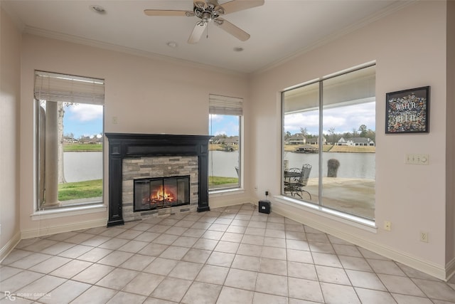 unfurnished living room with ceiling fan, a water view, a stone fireplace, and a healthy amount of sunlight